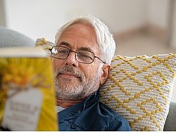 Älterer Mann liest ein Buch.