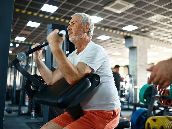 Älterer Mann an einem Kraftsportgerät