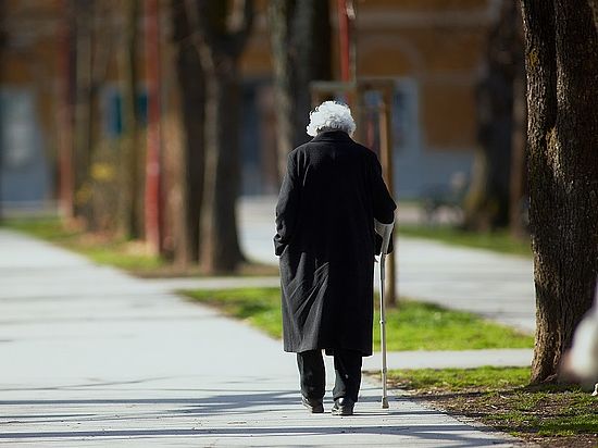 Alte Frau allein mit Gehhilfe unterwegs