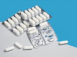 Blisterpackungen mit weißen Kapseln, einige entnommen